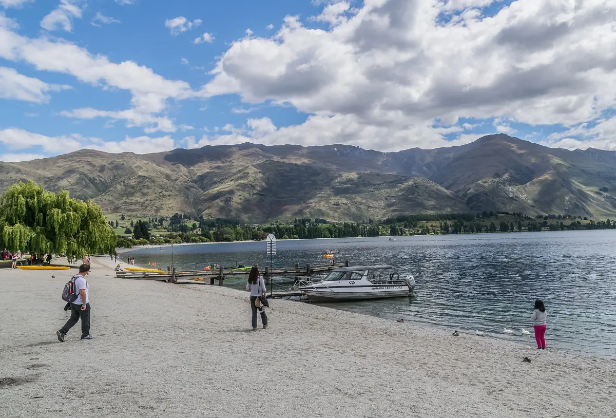 Boats and walkers on the shore of Lake Wanaka