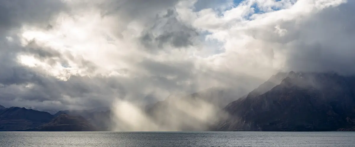 Sun breaking through clouds over Lake Hawea